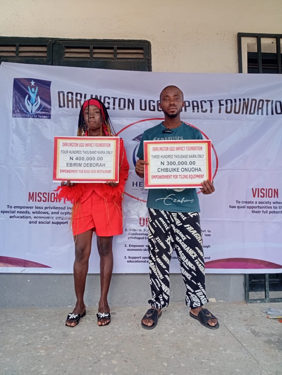 Two grant beneficiaries in front of the foundation banner