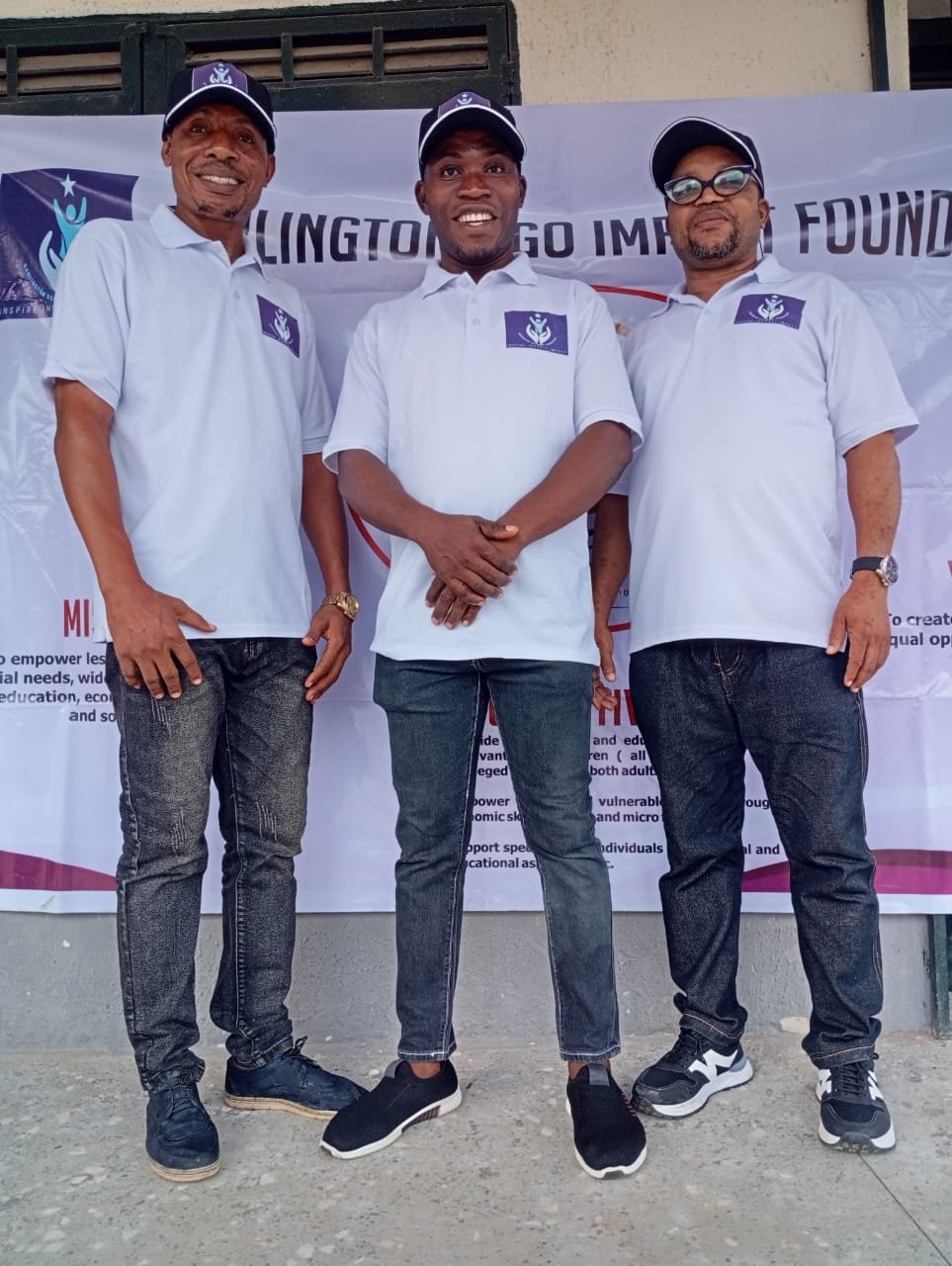 Three foundation team members in front of the foundation banner